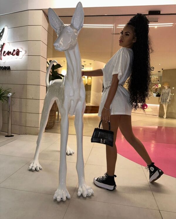 Megan acompañante de lujo Ibiza posando con una estatua de un perro Megan acompañante de lujo Ibiza posando con una estatua de un perro